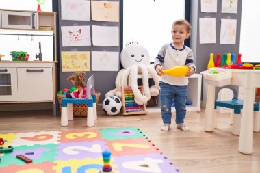 Anaokulunda pin bowlingi oynayan sevimli beyaz çocuk.