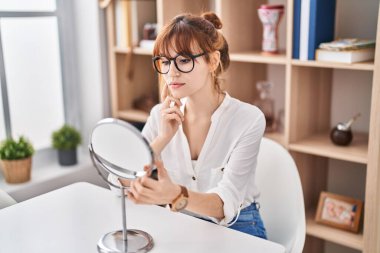 Genç bayan aynaya bakıyor.