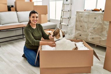 Evde köpekle oynarken kendine güvenen genç bir kadın.