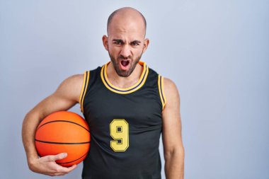 Sakallı, basketbol forması giyen, top tutan, ağzı açık, şüpheci ve alaycı görünen kel bir adam. 