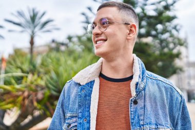 Genç İspanyol adam gülümsüyor parkın kenarına bakıyor.