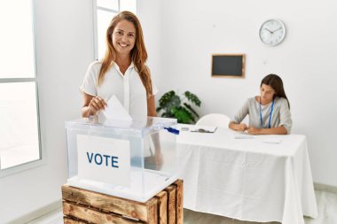 Anne ve kızı seçmen kurulunda kendine güvenen oylar vererek gülümsüyor.