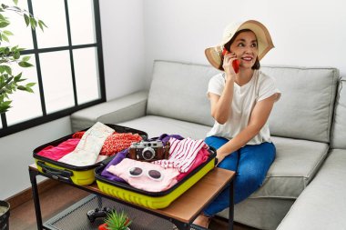 Orta yaşlı İspanyol kadın tatil için hazırlanıyor. Evde telefonla konuşuyor.