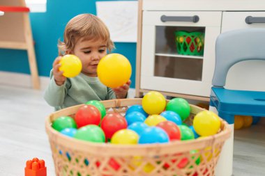 Sevimli İspanyol çocuk anaokulunda yerde oturmuş hayalarıyla oynuyor.