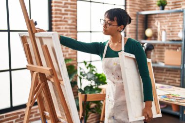 Resim stüdyosunda resim çizen genç, güzel İspanyol kadın sanatçı.