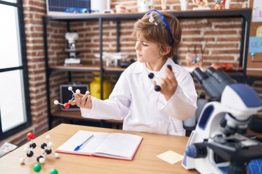 Sınıfta molekülleri tutan sevimli beyaz çocuk.