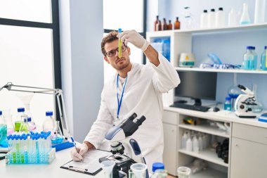 Laboratuvarda test tüpü tutan genç İspanyol bilim adamı.