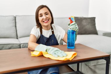 Orta yaşlı İspanyol kadın evde temizlikçi olarak çalışıyor.