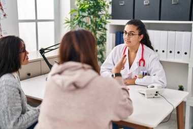 Three woman doctor and patients having medical consultation at clinic