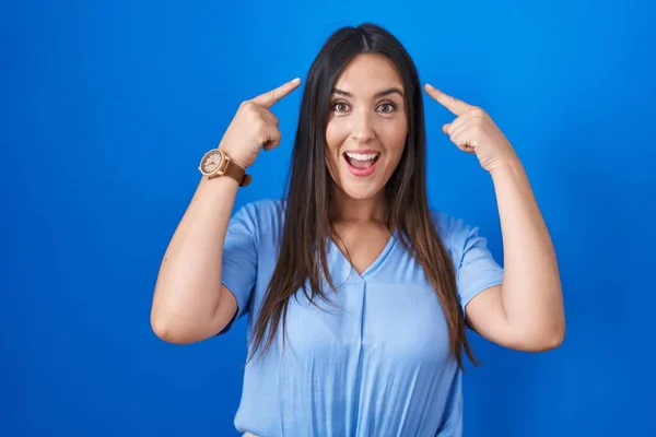 Young Brunette Woman Standing Blue Background Smiling Pointing Head Both — Stock Photo, Image