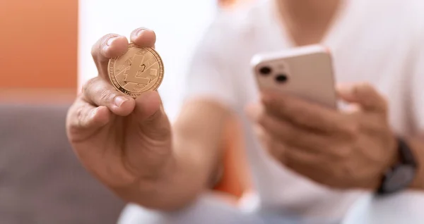 Young Hispanic Man Holding Litecoin Crypto Currency Using Smartphone Home — Foto de Stock