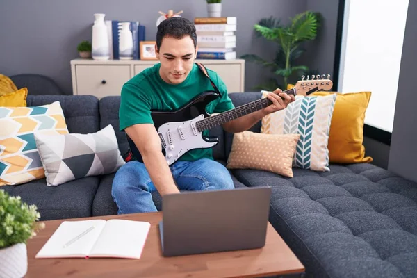 Young Hispanic Man Having Online Electrical Guitar Class Sitting Sofa — Stockfoto