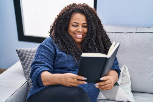 African American Woman Reading Book Sitting Sofa Home — Stock fotografie