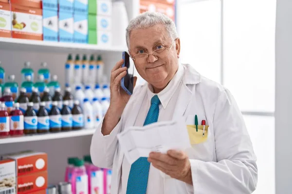 Middle Age Grey Haired Man Pharmacist Talking Smartphone Reading Prescription — Foto de Stock