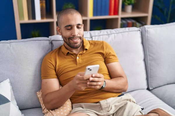 Mladý Latin Muž Pomocí Smartphone Sedí Pohovce Doma — Stock fotografie
