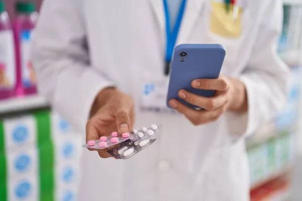 金发碧眼的年轻药剂师在药店用智能手机拿药 — 图库照片