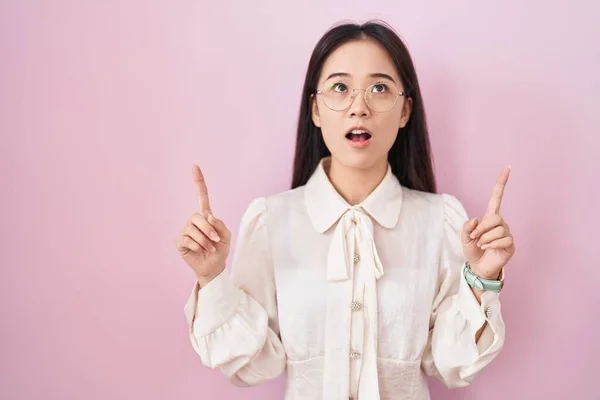 Young Chinese Woman Standing Pink Background Amazed Surprised Looking Pointing — Stockfoto