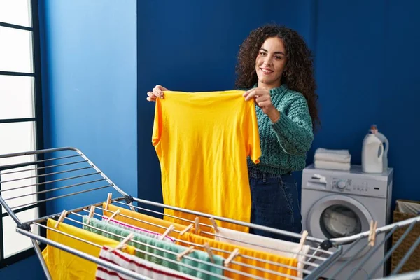 年轻美丽的惊慌失措的女人微笑着 自信地把衣服挂在洗衣房的晾衣绳上 — 图库照片