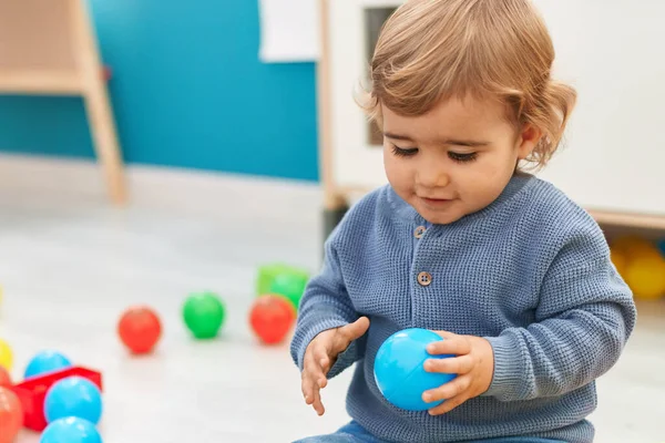 可敬的是 他的惊慌失措的幼儿在幼儿园的地板上玩着球 — 图库照片