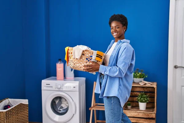 African American Woman Smiling Confident Holding Basket Clothes Laundry Room — 图库照片