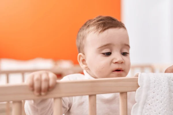 可爱的高加索婴儿站在摇篮上 在卧室里表情轻松 — 图库照片