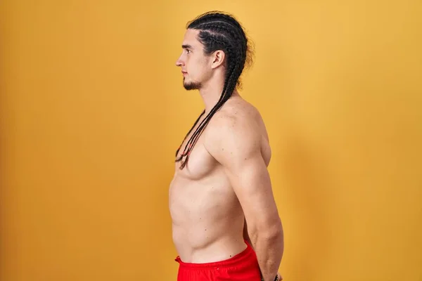 Hispanic Man Long Hair Standing Shirtless Yellow Background Looking Side — Stockfoto