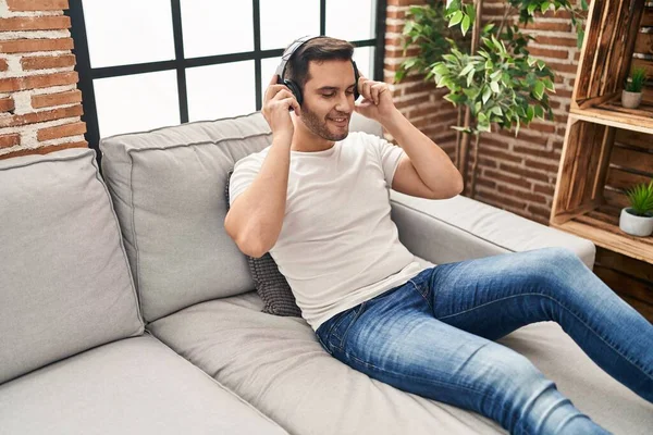 Jonge Spaanse Man Die Thuis Naar Muziek Luistert Zittend Bank — Stockfoto