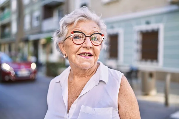 头发灰白的老年妇女自信地站在街上笑 — 图库照片