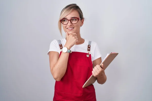 Young Blonde Woman Wearing Waiter Uniform Holding Clipboard Hand Chin — Stock Photo, Image
