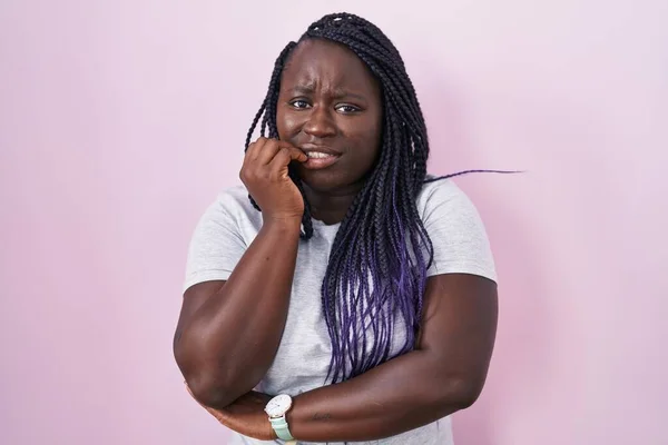 ピンクの背景に立っている若いアフリカの女性は 口の爪をかむ上で手で強調し 緊張している 不安の問題 — ストック写真