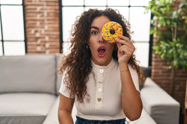 Young Hispanic Woman Holding Tasty Colorful Doughnut Eye Scared Amazed — Stockfoto