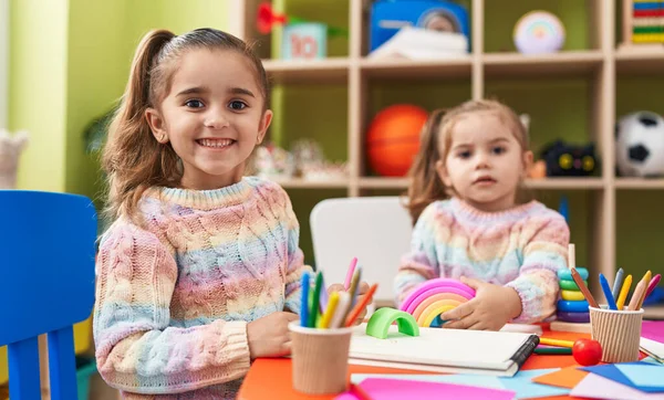 stock image Two kids preschool students sitting on table drawing on paper at kindergarten