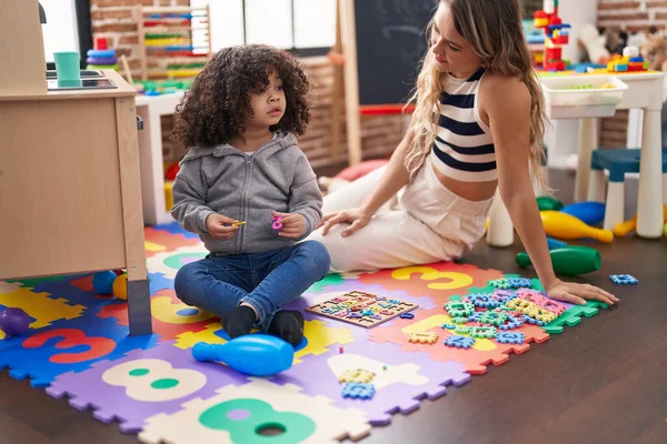 Teacher Toddler Playing Maths Puzzle Game Sitting Floor Kindergarten — Zdjęcie stockowe