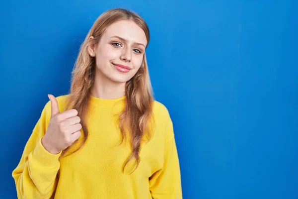 Young Caucasian Woman Standing Blue Background Doing Happy Thumbs Gesture —  Fotos de Stock