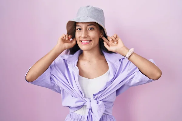 Young Hispanic Woman Standing Pink Background Wearing Hat Smiling Pulling — Stockfoto