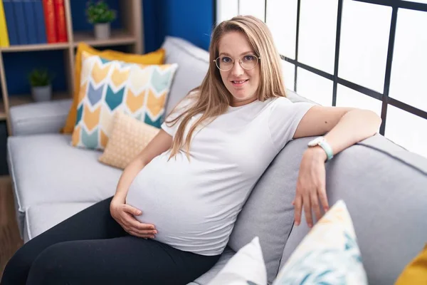 Νεαρή Έγκυος Γυναίκα Αγγίζει Την Κοιλιά Κάθεται Στον Καναπέ Στο — Φωτογραφία Αρχείου