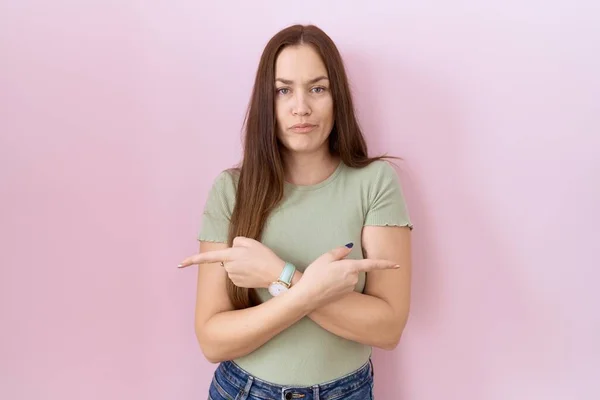 Beautiful Brunette Woman Standing Pink Background Pointing Both Sides Fingers — Stockfoto
