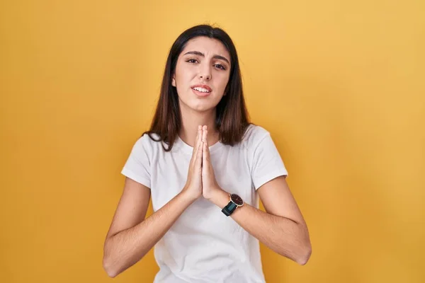 Young Beautiful Woman Standing Yellow Background Begging Praying Hands Together — Foto de Stock