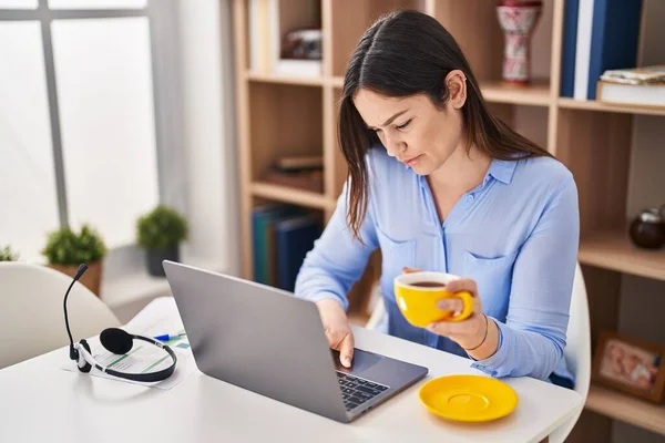 在家里用笔记本电脑喝咖啡的年轻妇女 — 图库照片