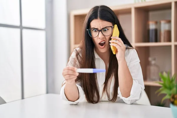 Young Brunette Woman Holding Pregnancy Test Result Speaking Phone Shock — Stockfoto