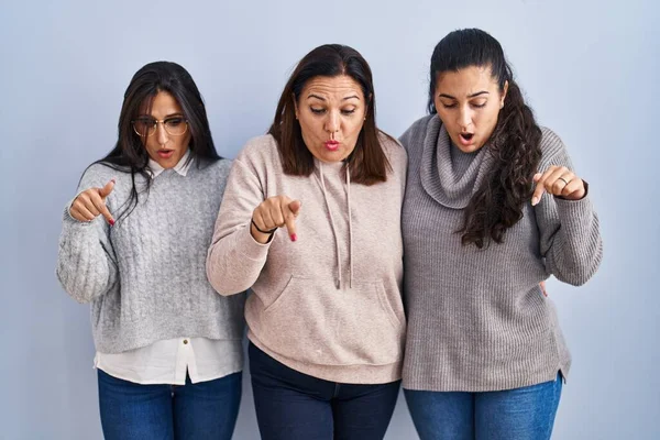 Mother Two Daughters Standing Blue Background Pointing Fingers Showing Advertisement — Stockfoto
