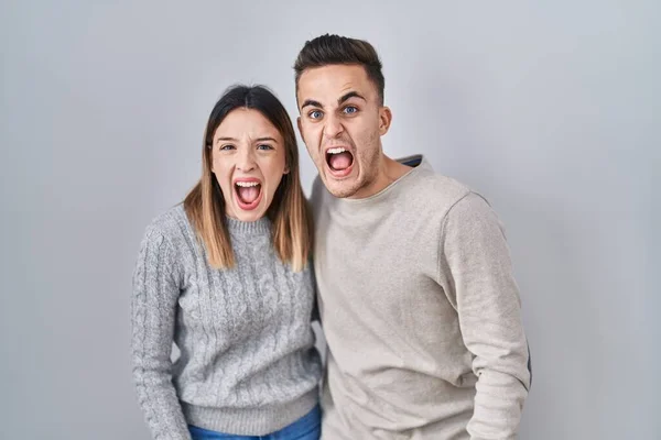 Young Hispanic Couple Standing White Background Angry Mad Screaming Frustrated — 图库照片