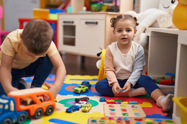 2人の子供が車のおもちゃで遊んでいて 数学ゲームは幼稚園の床に座っています — ストック写真