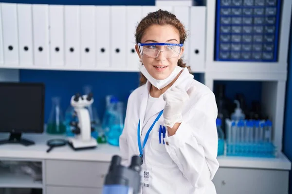 Young Caucasian Woman Working Scientist Laboratory Pointing Thumb Side Smiling — Stockfoto