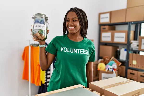 Afrikalı Amerikalı kadın yeni evinde karton kutu paketliyor.