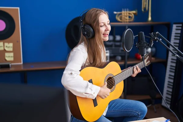 若い白人女性ミュージシャン歌を歌いますクラシックギターを演奏音楽スタジオで — ストック写真