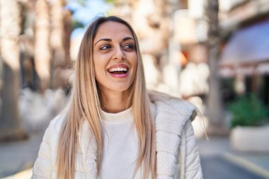 Sokakta kendinden emin gülümseyen genç bir kadın