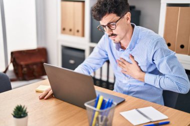 Young caucasian man business worker using laptop suffering chest pain at office