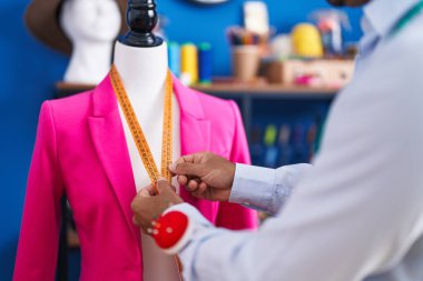 Dikiş atölyesinde terzi ceketi giyen genç bir İspanyol.