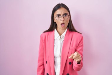 Young hispanic woman wearing business clothes and glasses pointing displeased and frustrated to the camera, angry and furious with you 